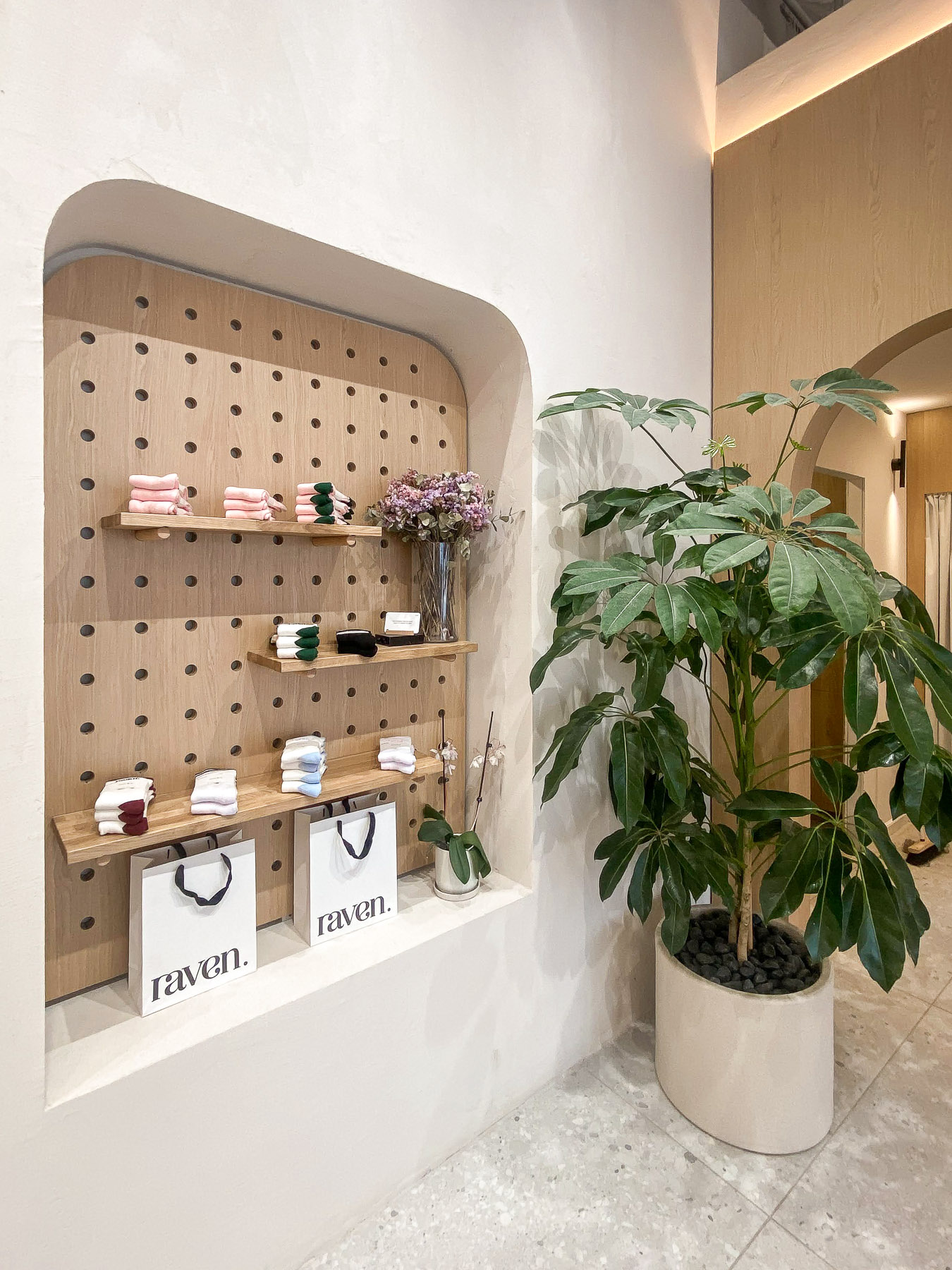 קיר תצוגה עם מדפי עץ ונגרות בהתאמה אישית בחנות בגדי ספורט לנשים בחיפה